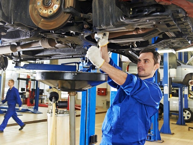 Service Technician Inspecting Car